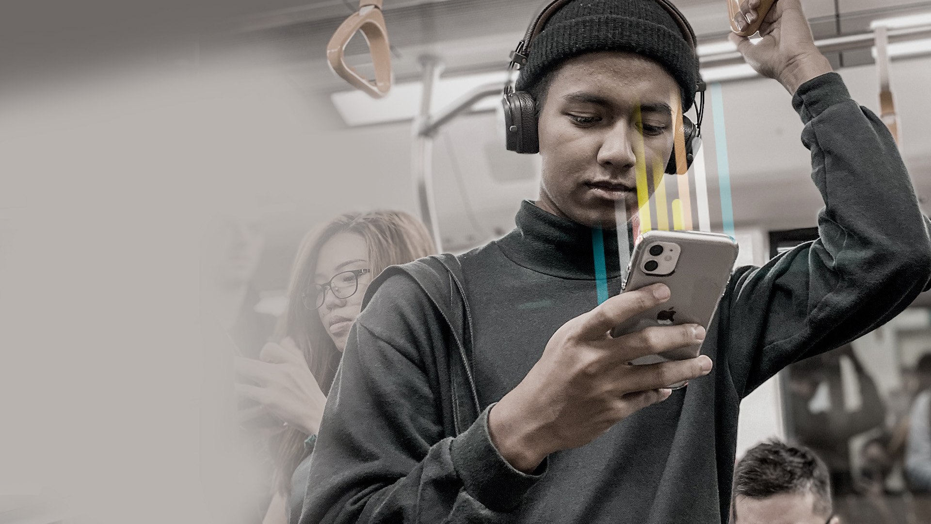 A young man looks at his smartphone while travelling on public transport.